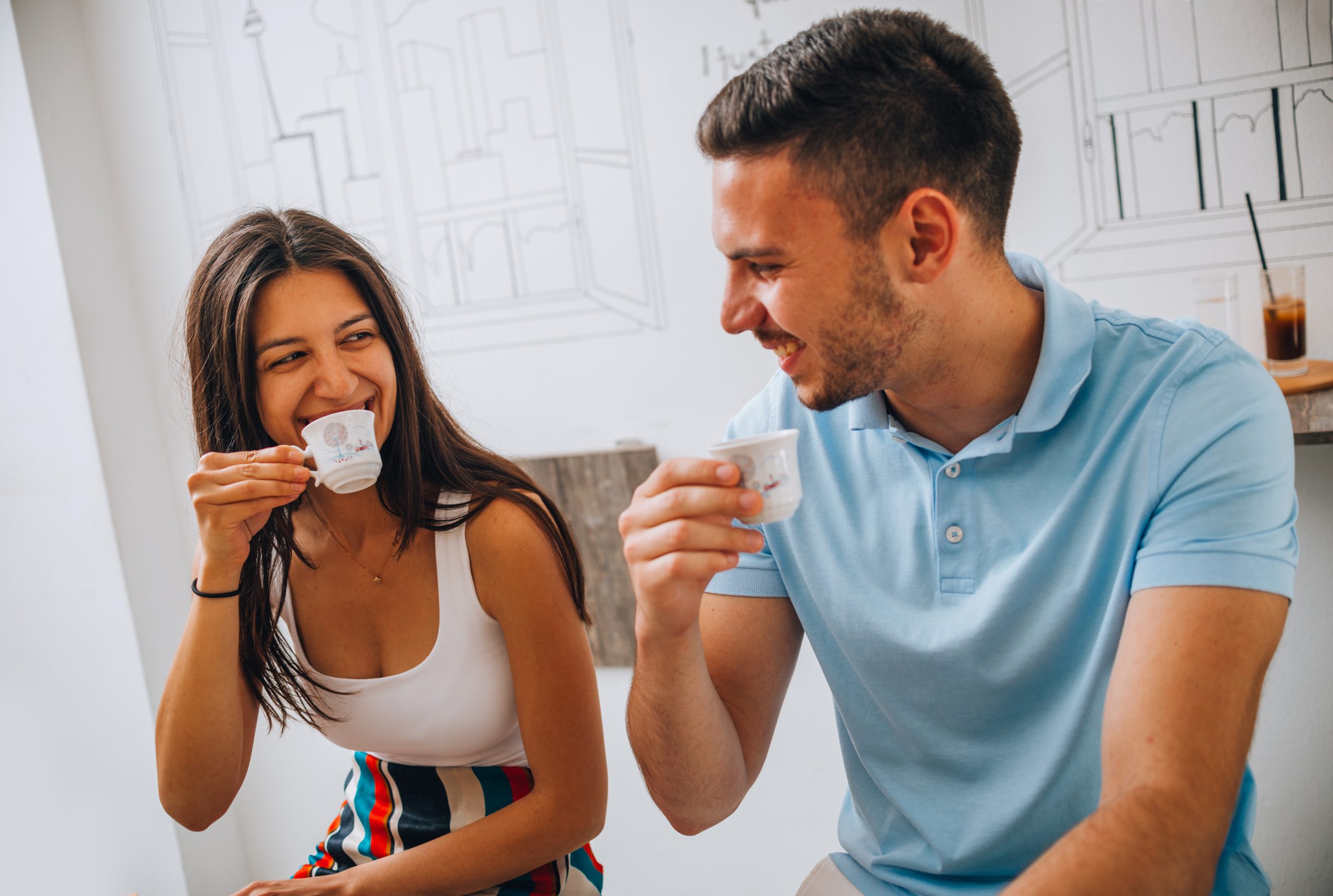 Attractive young man and his girlfriend having coffee in cafe